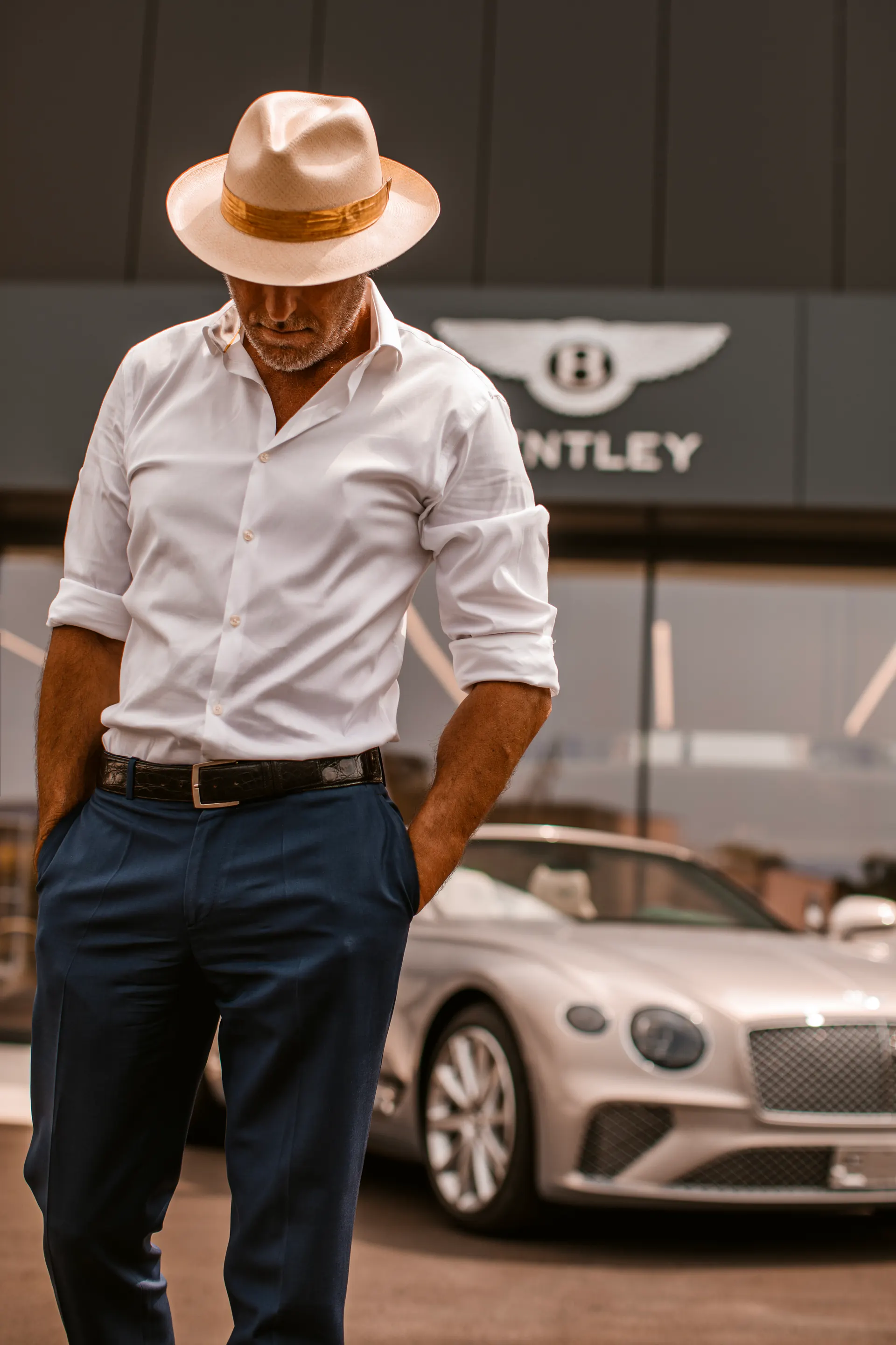 Mr Panama portrait beside a Bentley